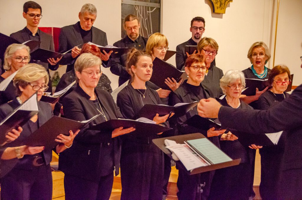 Sängerinnen und Sänger des Singkreis Raaba in Schwarz mit Notenmappen, konzentriert auf das Dirigat